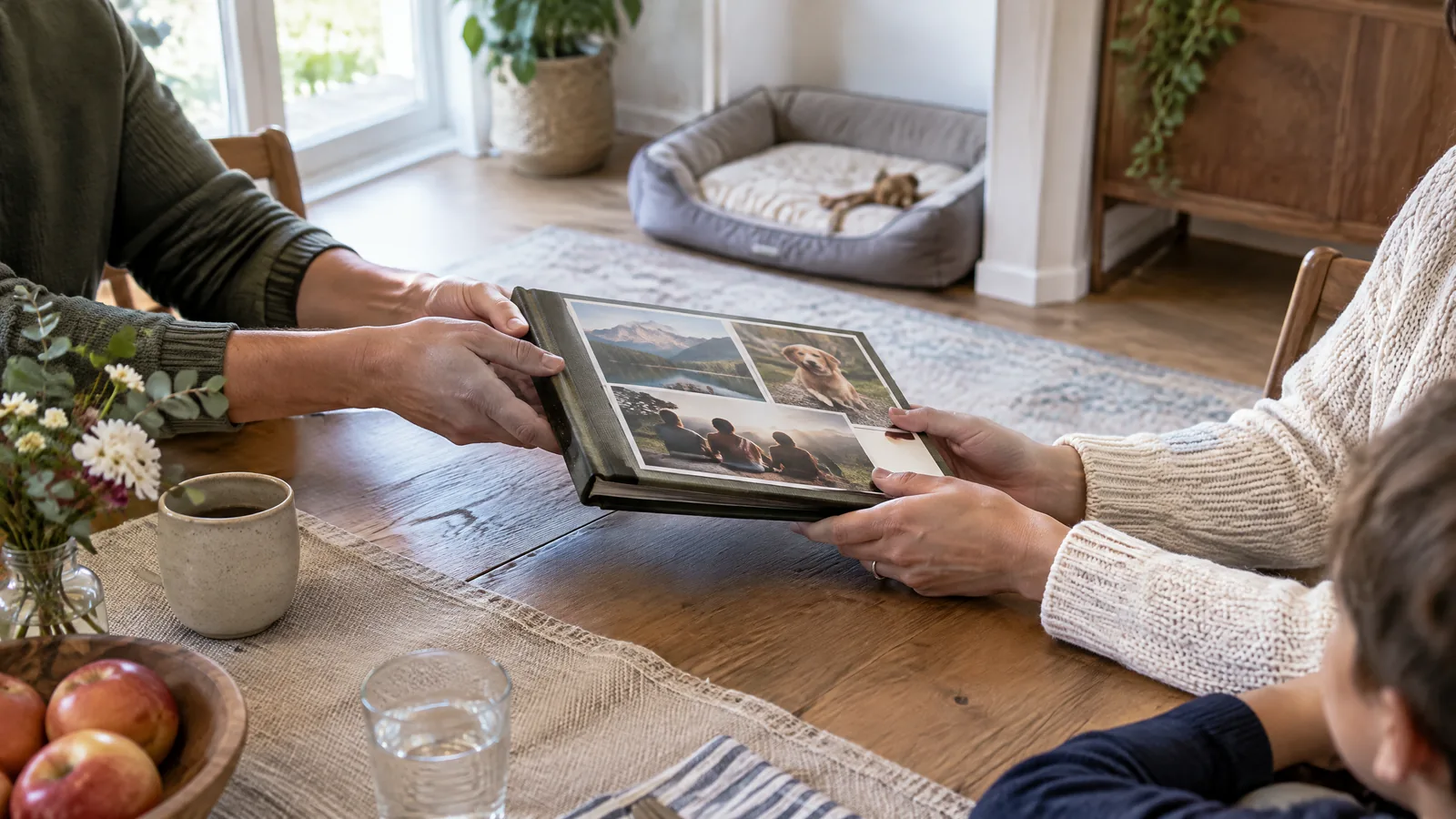 An older adult and a younger family member look through companion-animal photographs at a softly lit kitchen table.